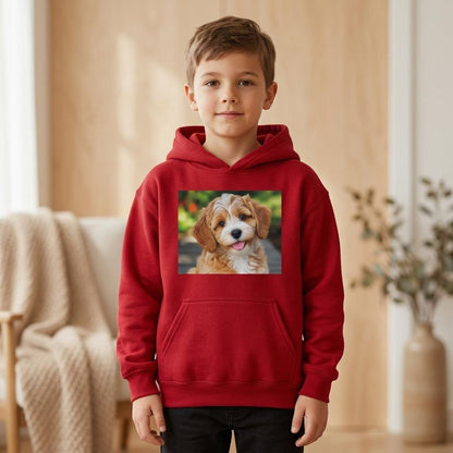 A young boy wearing a red pullover hoodie with a square graphic print of a brown and white puppy on the chest, standing in a warm, modern indoor room.